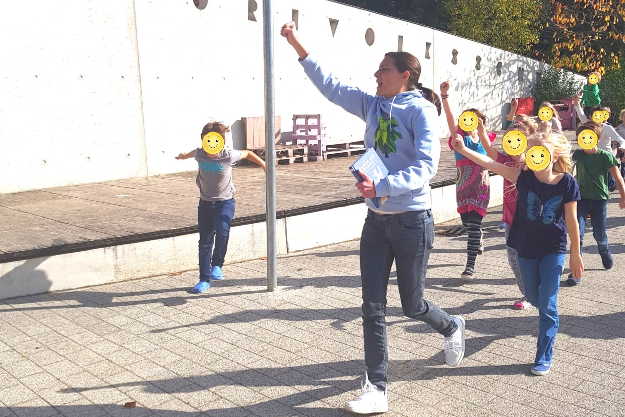 Autorenlesung-Grundschule-Erding-Actioneinlage-Paul-Pulli Autorin Alexandra Wagner läuft während Mitmach-Lesung mit Kindern einer Runde mit Superhelden-Pose
