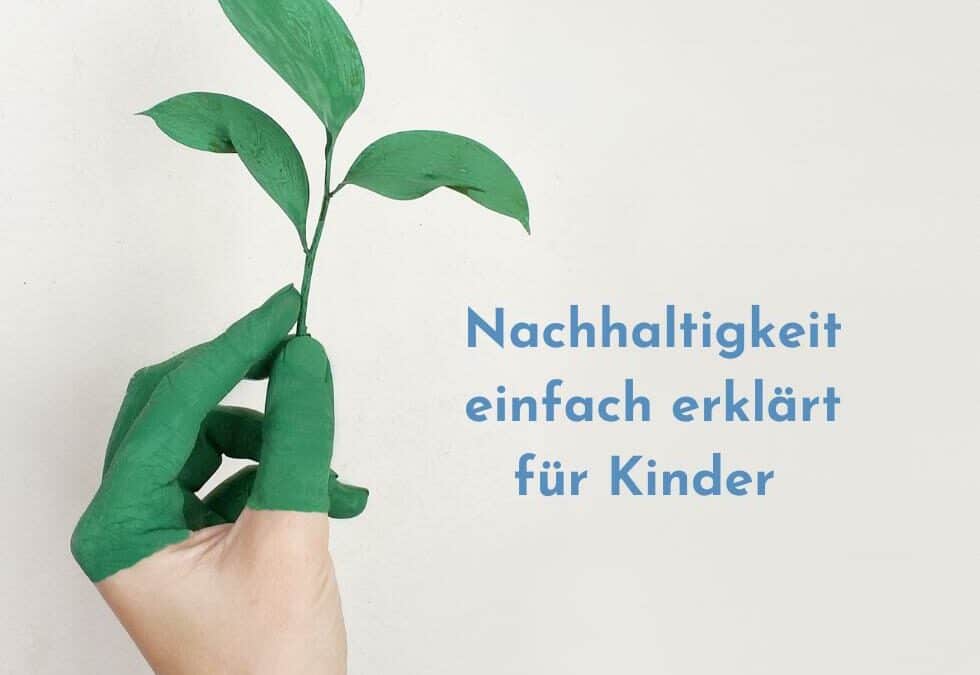 Hand halb grün angemalt hält Pflanze vor weißer Wand mit Text Nachhaltigkeit erklärt für Kinder