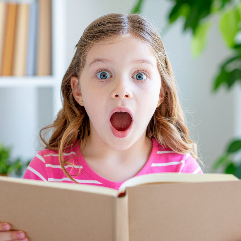 Mädchen schaut über aufgeschlagenes Buch und staunt mit offenem Mund