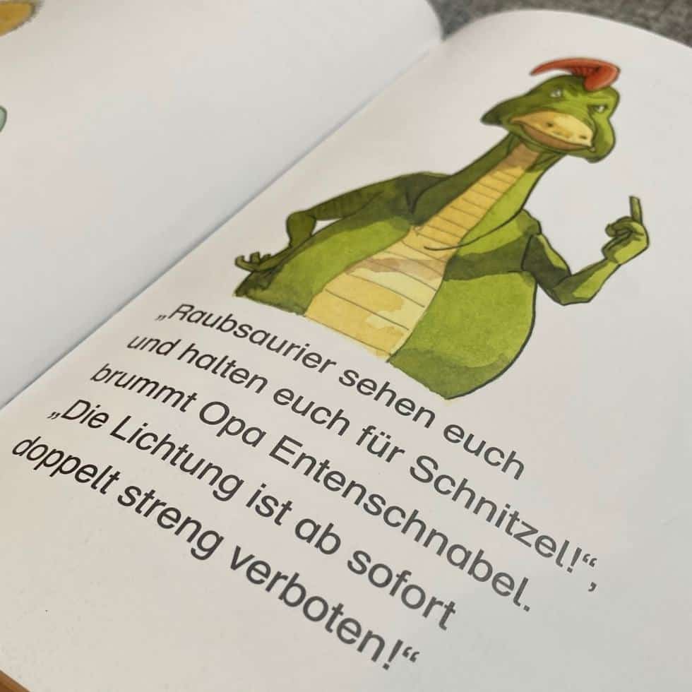Innenseite eines Ersteleserbuches mit großer Schrift und Dino-Illu