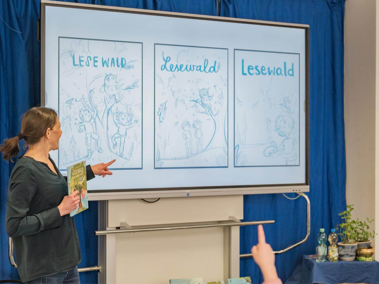Alex Wagner zeigt Cover-Entwürfe des Buches Lesewald, Der Zauber erwacht