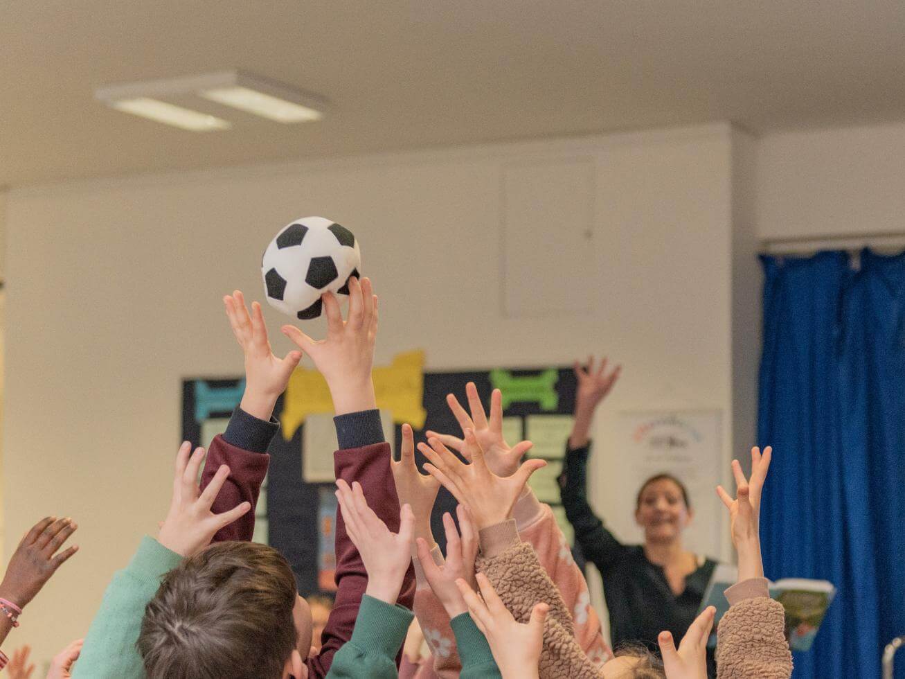 Kinder fangen kleinen Stoff-Fussball, den Alex Wagner geworfen hat
