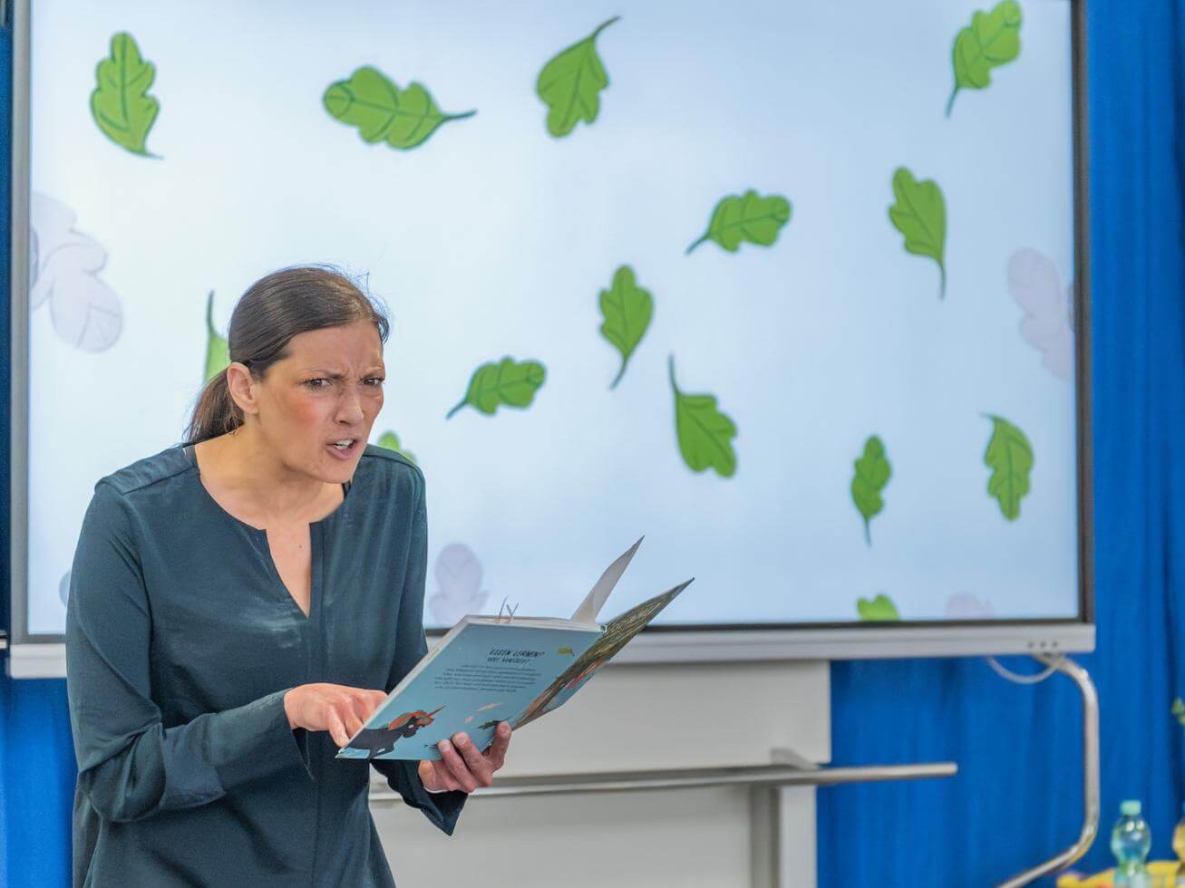 Alex Wagner macht während Vorlesen Grimasse