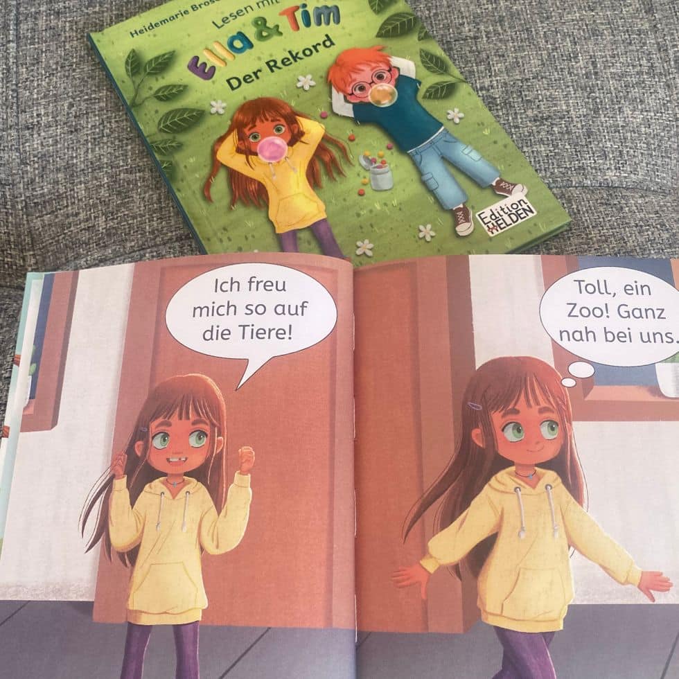 Aufgeschlagenes Erstleserbuch mit kurzen Sätzen und Illustration, darüber das Cover "Ella & Tim"