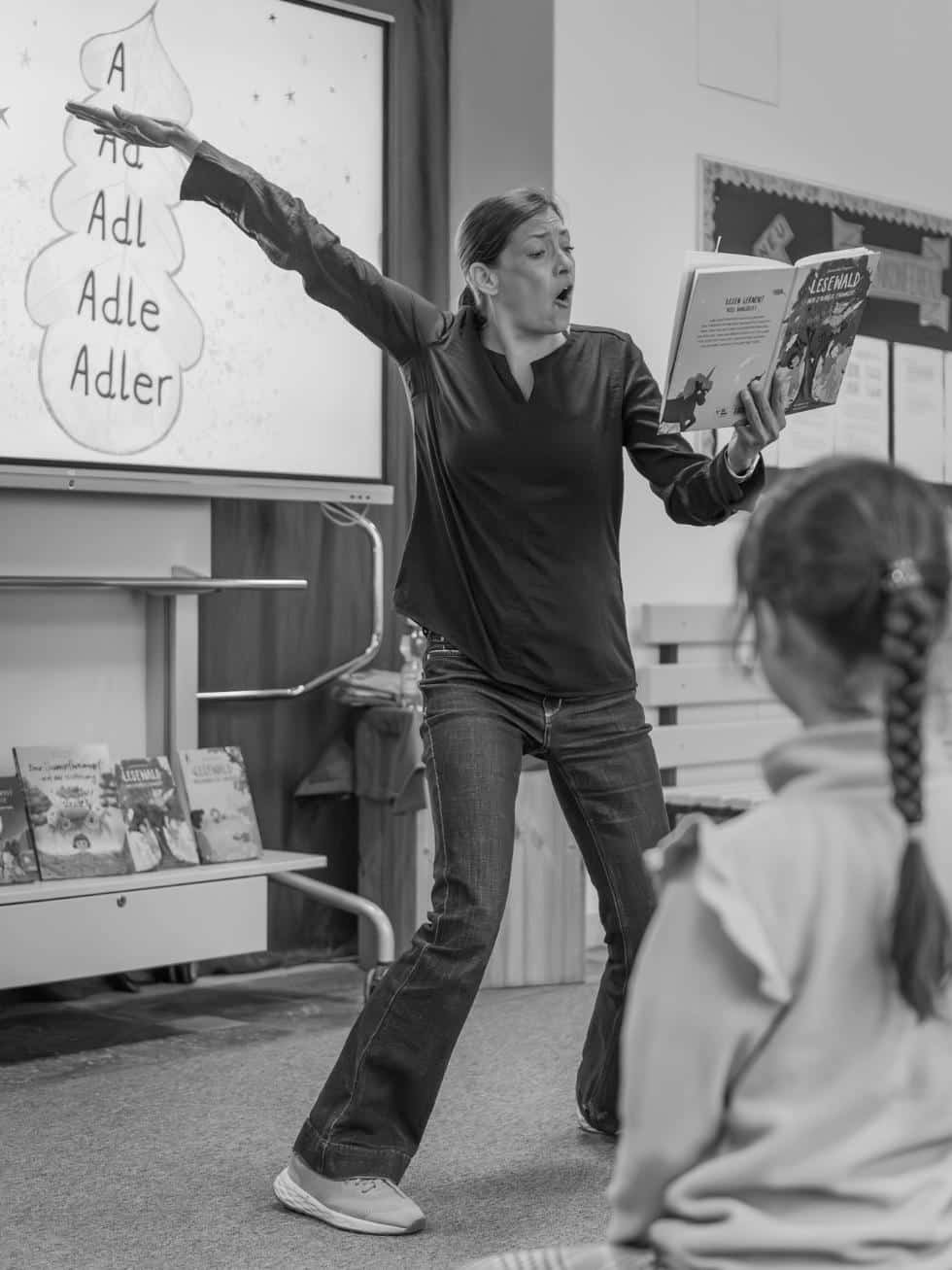 Autorin Alexandra Wagner imitiert mit weit ausgebreiteten Armen einen Adlerflug während einer LESEWALD-Lesung