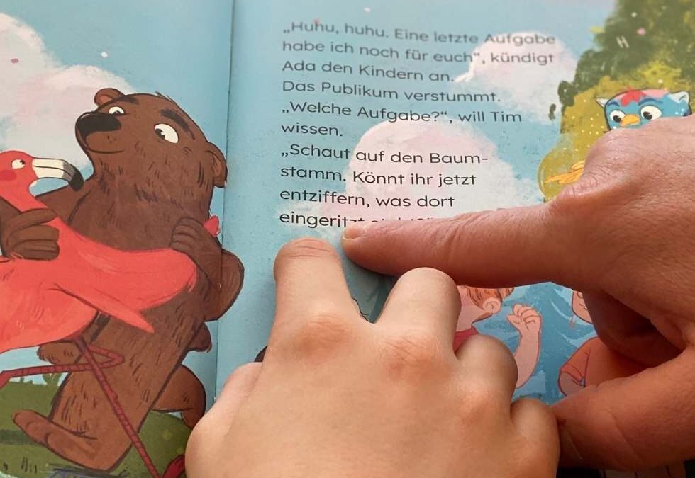 Nahaufnahme von Zeigefinger, die auf Text in illustriertem Buch »Lesewald« zeigen